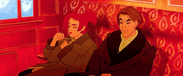 a man and woman are sitting on a red couch