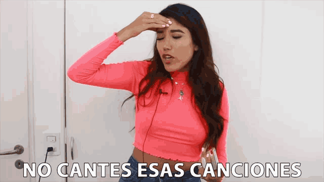 a woman in a pink crop top holds her hand to her forehead with the words no cantes esas canciones behind her
