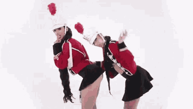 a man and a woman in uniforms are dancing together .