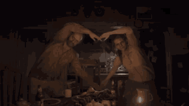 a man and a woman are sitting at a table with a bottle of heinz ketchup on it