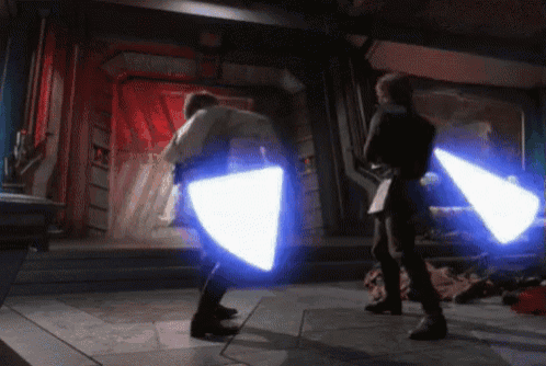 a couple of people standing next to each other holding lightsabers