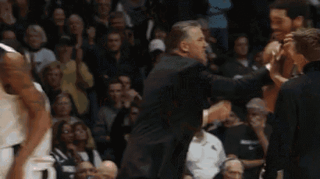 a basketball player with the number 20 on his jersey is being helped by a referee