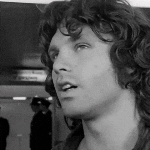 a black and white photo of a man with curly hair looking up