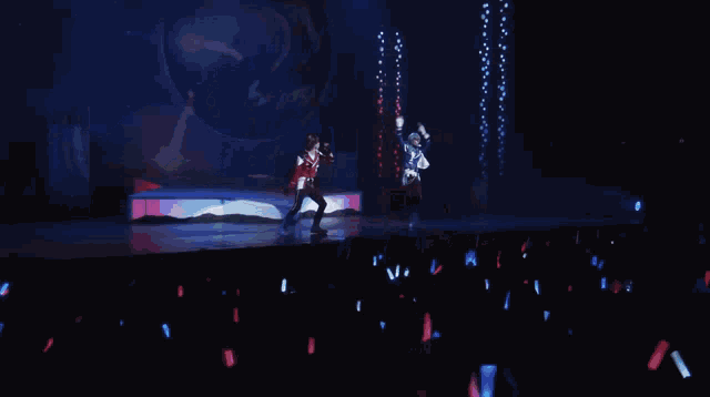 a couple of people are dancing on a stage and one of them is blue