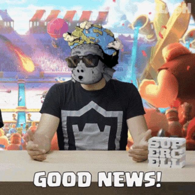 a man wearing a mask and sunglasses is sitting at a table with the words good news behind him