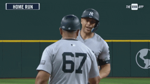 a new york yankees baseball player is being congratulated by another player