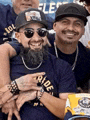 a group of men are posing for a picture and one of them has a beard and sunglasses on .