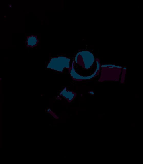 a yellow object is glowing in the dark and has a hat on it .