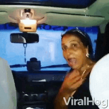 a woman is sitting in the driver 's seat of a car .
