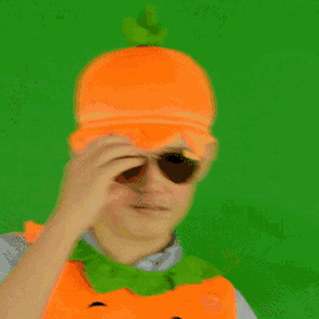 a man wearing an orange hat and an orange vest is drinking from a bottle