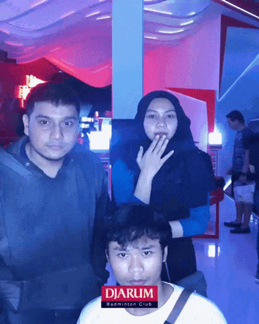 a man and a woman are posing for a picture with the words djarum badminton club