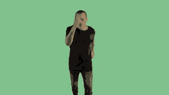 a man in a black shirt is jumping in the air on a green background