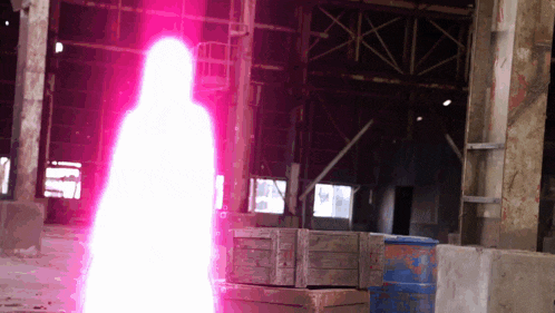 a pink light is coming out of a building with boxes in the foreground