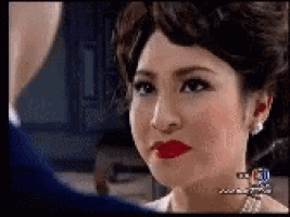 a woman with red lipstick is looking at a man in a blue suit .