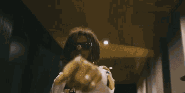 a blurry picture of a person with dreadlocks covering their face with a hood .