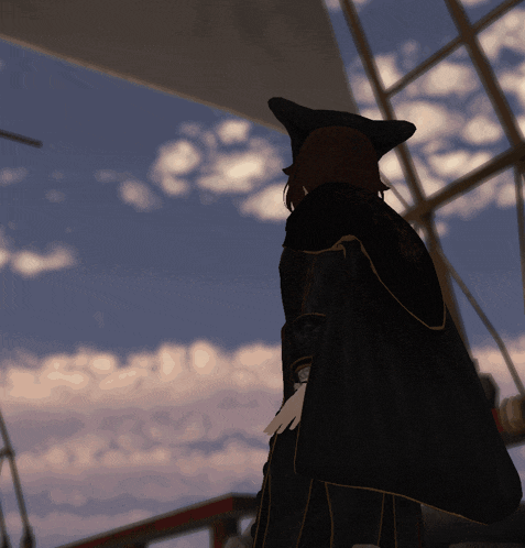 a woman in a black cape stands in front of a blue sky