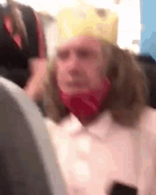 a blurry picture of a person wearing a crown and a red mask .
