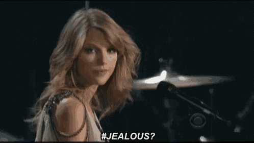 a woman is standing in front of a microphone and says # jealous