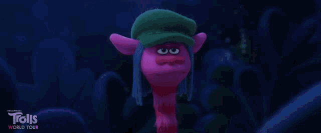 a pink troll wearing a green hat from the movie trolls world tour .