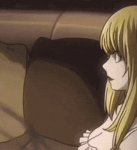 a blonde anime girl is sitting on a brown couch .