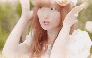 a woman wearing a white dress and a flower crown is making a funny face .