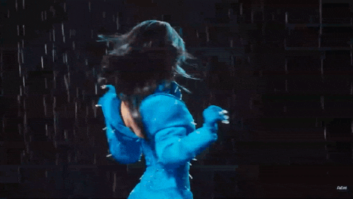 a woman in a blue costume is standing in the rain