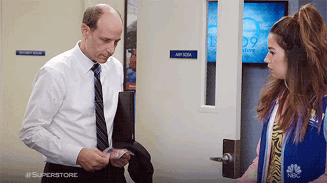 a man standing next to a woman in front of a door that says any soda