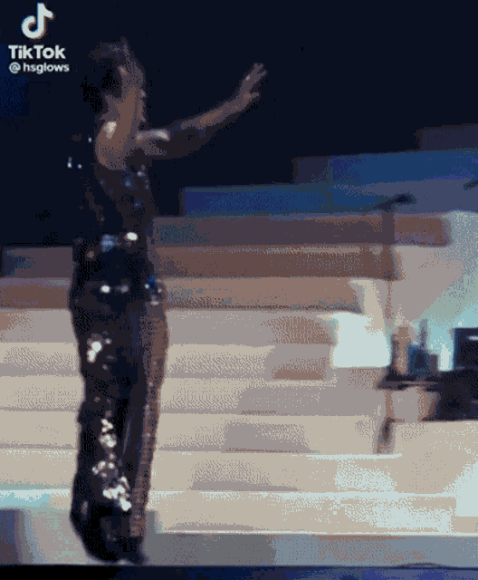 a woman in a sequined outfit is dancing on a stage with a tik tok watermark