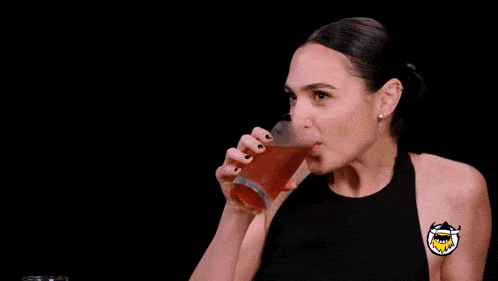 a woman is holding a glass of beer and making a face in front of cnn