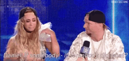 a man and a woman are sitting next to each other on a stage and talking into a microphone .