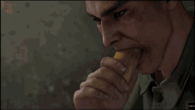 a man in a green shirt is eating a piece of bread with a bite taken out of it