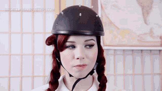 a woman wearing a helmet with the website ludellahairfetish.com written on the bottom