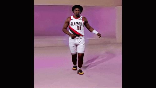 a man wearing a blazers jersey and shorts walks down a runway