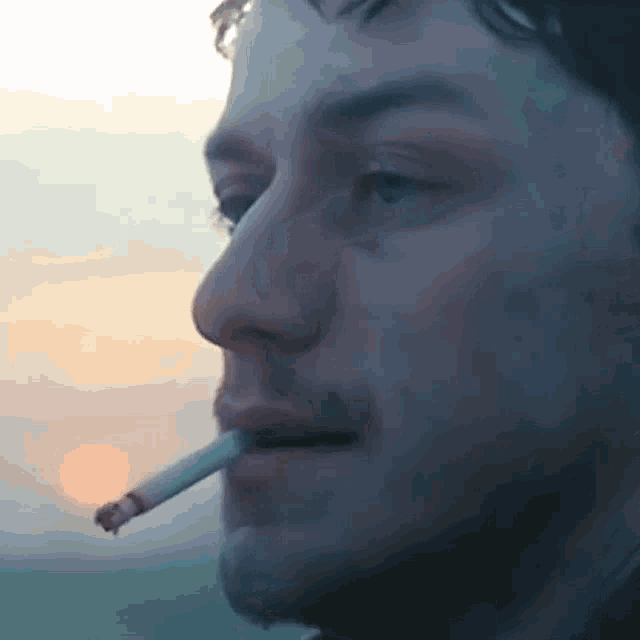 a man is smoking a cigarette in a close up of his mouth .