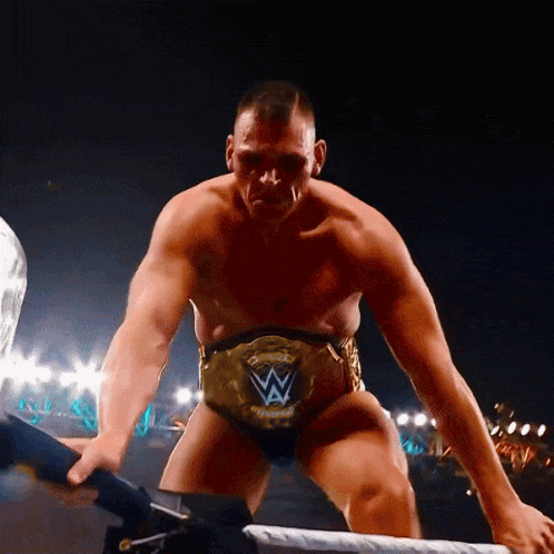 a man in a wrestling ring with a belt that says ' champions ' on it