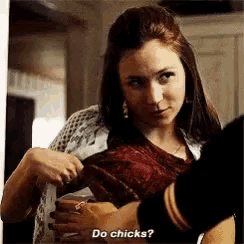 a woman is holding a baby and talking to another woman .
