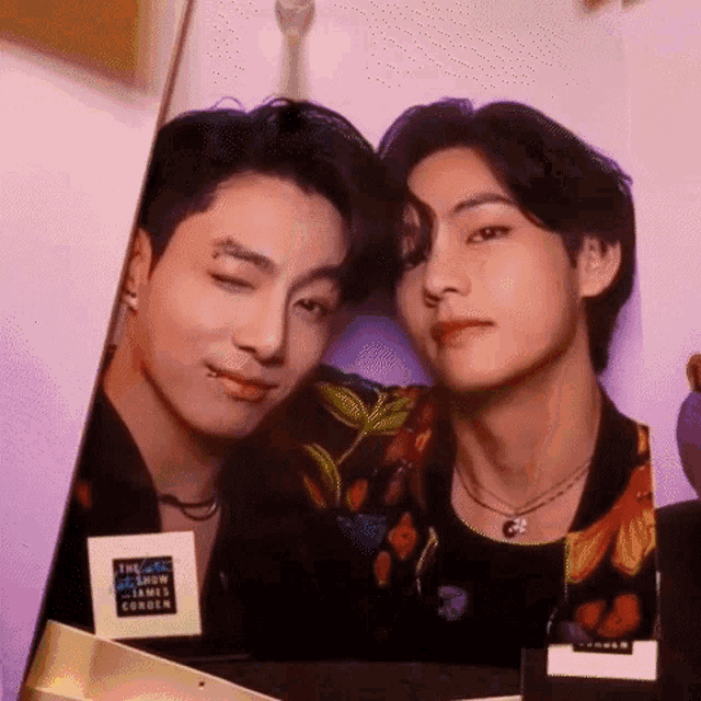 two men are posing for a picture together in a room .