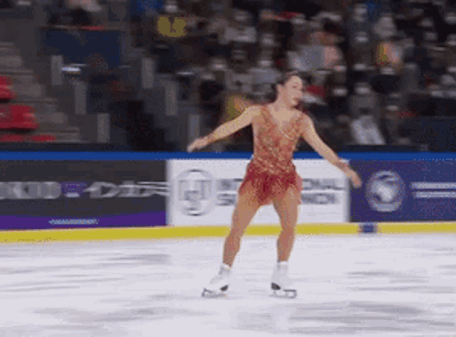 a woman in a red dress is skating on a rink