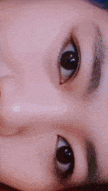 a close up of a person 's eyes with a pink background