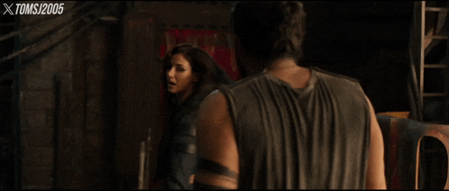 a man and a woman are looking at each other with xtoms written on the bottom of the screen