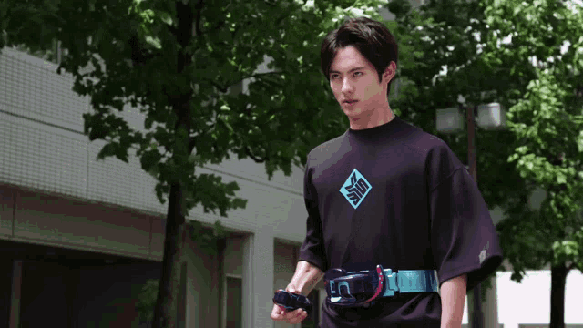 a man wearing a black t-shirt with a blue diamond on it