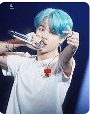a young man with blue hair is holding a microphone in his mouth .