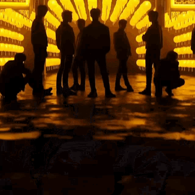 a group of people standing in front of a wall of yellow lanterns