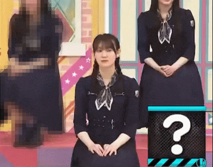 a woman in a dress is sitting in front of a question mark on a stage .