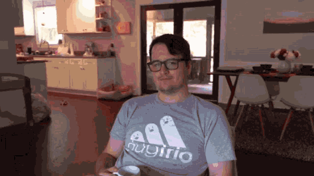 a man wearing glasses and a grey shirt that says fugirio
