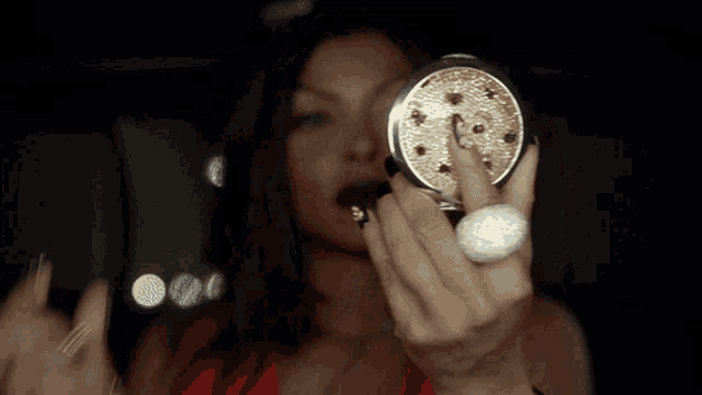 a woman with a ring on her finger is looking at herself in a mirror