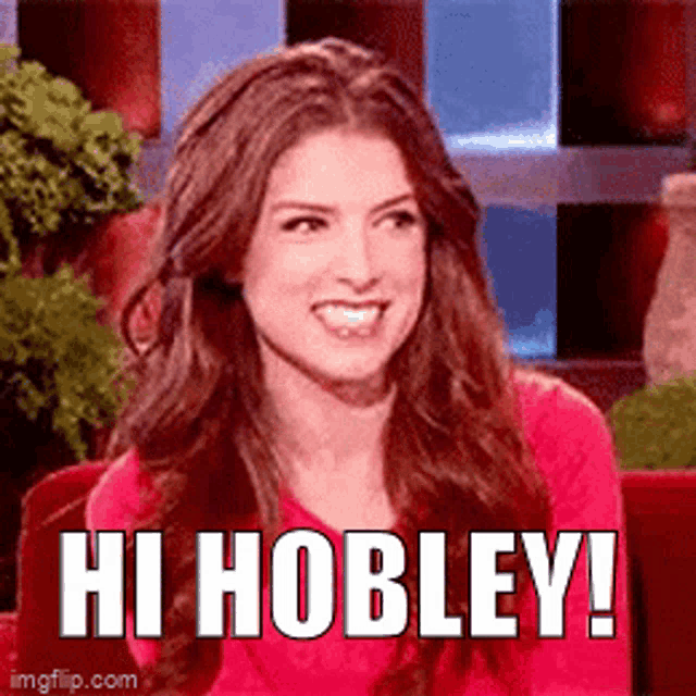 a woman in a red shirt is smiling and says hi hobley !