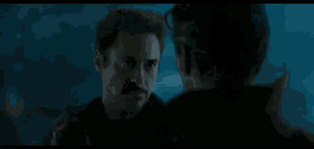 a man with a mustache is talking to another man