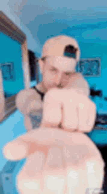 a man wearing a hat is giving the middle finger to the camera .