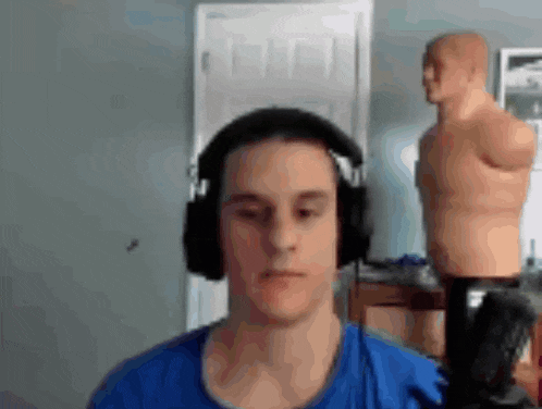 a man wearing headphones is sitting in front of a punching bag in a room .